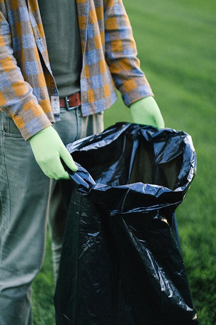 Three blue plastic rubbish bags, filled and tied at the top, are placed on the pavement next to the rear of a white delivery van. The bags appear to contain household waste or debris and are positione